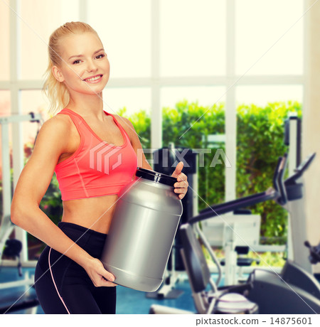 smiling sporty woman with jar of protein 14875601