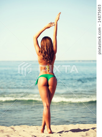 young woman sunbathing on beach 14875603