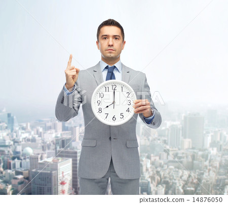 businessman in suit holding clock with 8 o'clock businessman in suit holding clock with 8 o'clock 14876050