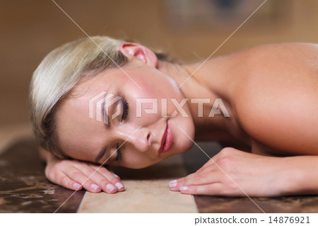 young woman lying on hammam table in turkish bath 14876921