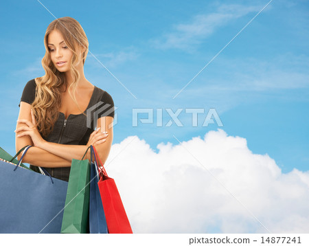 young woman with shopping bags over blue sky 14877241