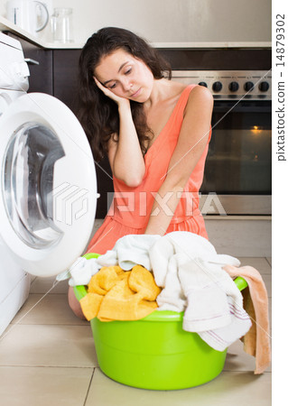 Sad woman washing clothes in machine 14879302