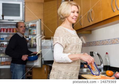 Senior spouses at modern kitchen 14879369
