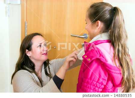 Mother dressing her daughter 14880535