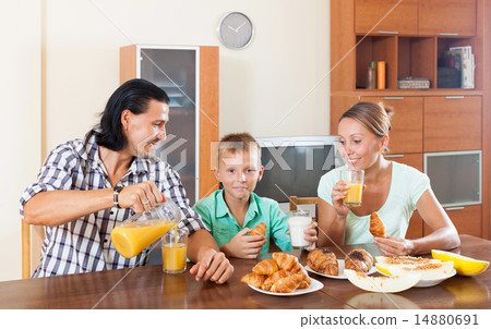 family having breakfast with croissants and juice in morning family having breakfast with croissants and juice in morning 14880691