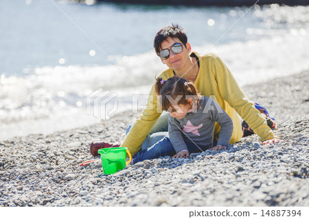 Mother and daughter having fun on the beach 14887394