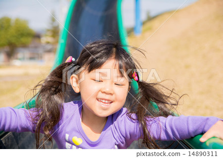 Girls playing on the slide at the park Girls playing on the slide at the park 14890311