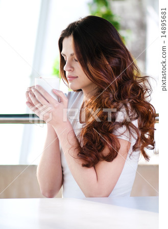 Woman sitting in a cafe with a coffe Woman sitting in a cafe with a coffe 14895681
