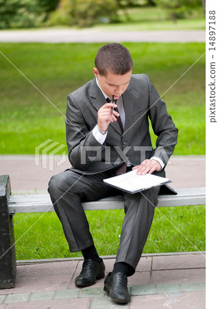 business man working with papers at park. Student 14897188