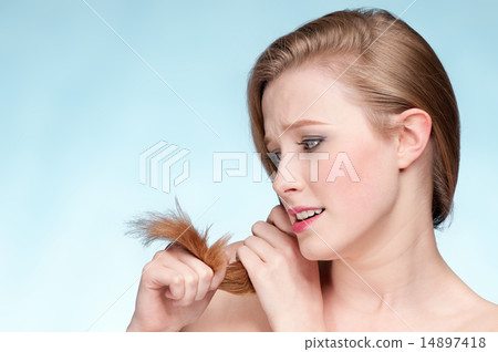Close up portrait of young displeasure woman with hair ends Close up portrait of young displeasure woman with hair ends 14897418