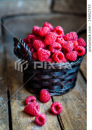 Raspberries in a basket on rustic wooden background 14902555