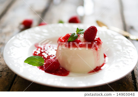 Delicious italian dessert panna cotta with raspberry sauce and m 14903048