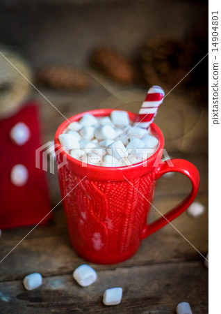 Red knitted mug filled with hot chocolate and marshmallows on wo 14904801