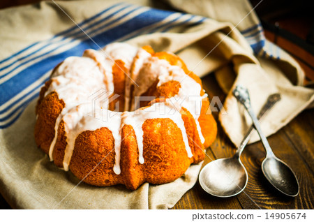 Bundt cake with white glaze on rustic background Bundt cake with white glaze on rustic background 14905674