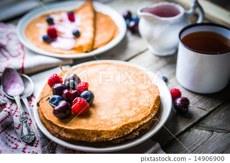 Pancakes with berries on wooden background 14906900