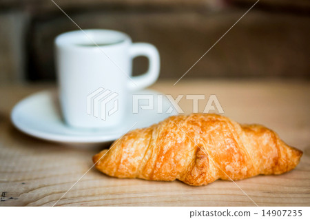 Black croissants with black coffee on wooden background Black croissants with black coffee on wooden background 14907235