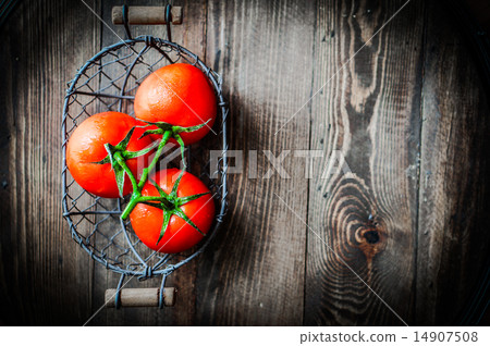 Fresh tomatoes in antique basket on wooden background 14907508