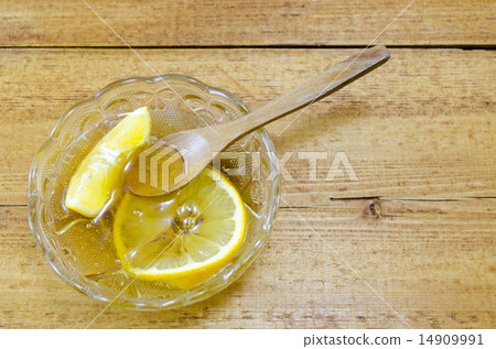 Glass plate filled with honey and lemon slices 14909991