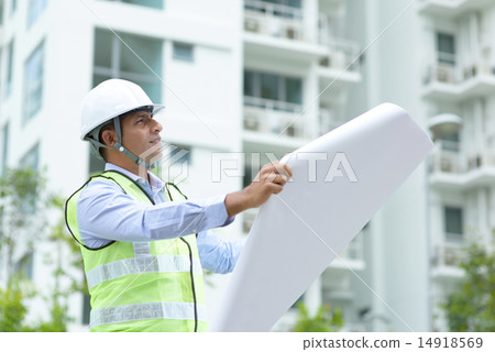 Indian construction engineer looking at site plans Indian construction engineer looking at site plans 14918569