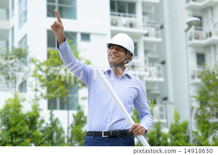 Indian construction engineer holding blueprints Indian construction engineer holding blueprints 14918630