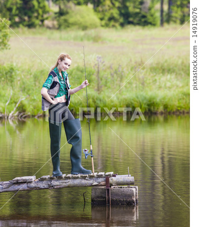 young woman fishing on pier at pond 14919076