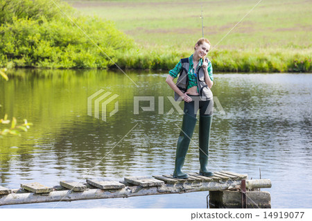young woman fishing on pier at pond 14919077