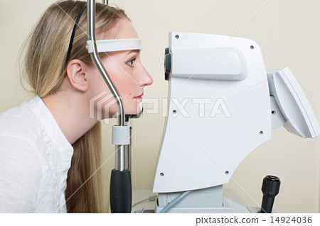Young woman having her eyes examined by an eye handsome elderly doctor 14924036