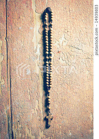 rosary hanging on old wooden wall 14939803
