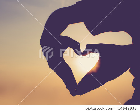 Silhouette hand in heart shape during sunset 14948933