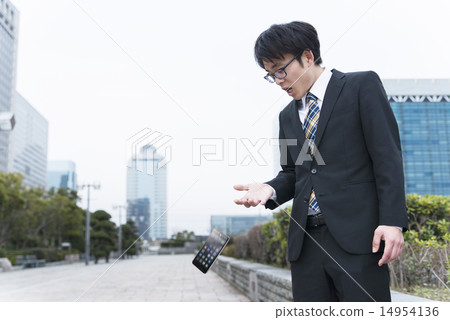 A businessman who is surprised to drop a smartphone 14954136
