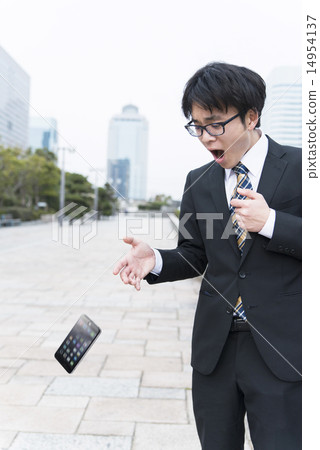 A businessman who is surprised to drop a smartphone 14954137