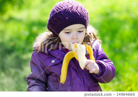 Small girl eating a banana in the park Small girl eating a banana in the park 14964669