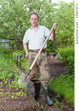 Man digs up a garden-bed with the first sprouts on Man digs up a garden-bed with the first sprouts on 14967973