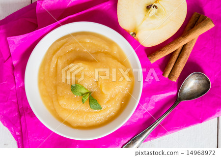 Applesauce on pink paper and spoon 14968972