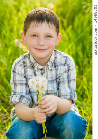 Boy on summer nature with dandelions smilling 14969303