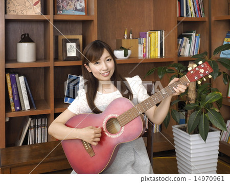 A woman playing the guitar A woman playing the guitar 14970961