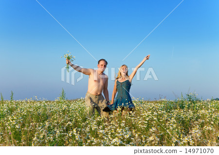 happy young pair in the field of chamomiles happy young pair in the field of chamomiles 14971070