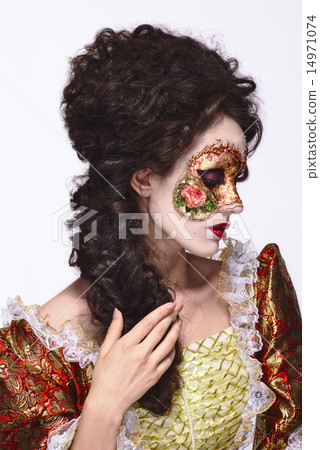 Venetian mask. Beautiful woman in vintage dress and a mask on hi 14971074
