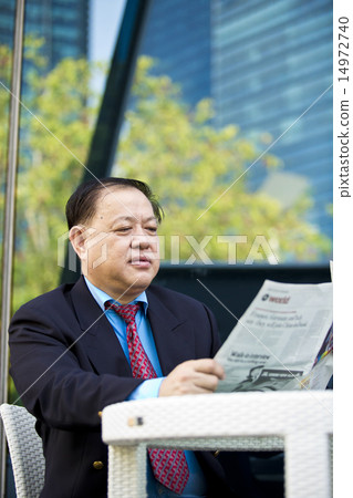 Asian businessman reading newspaper 14972740