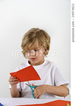 boy cuts red paper 14973621