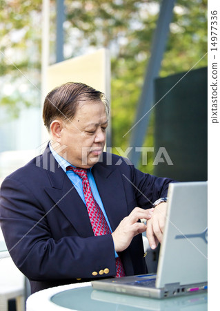 Asian businessman looking at watch 14977336