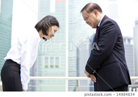 Asian businessman & female executive bowing 14984834