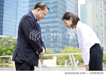 Asian businessman & female executive bowing 14984836