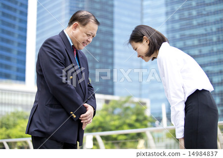 Asian businessman & female executive bowing 14984837