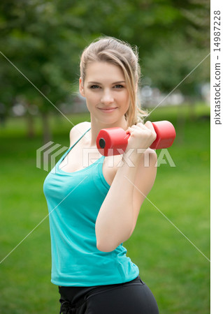 Sports girl exercise with dumbbells in the park 14987228