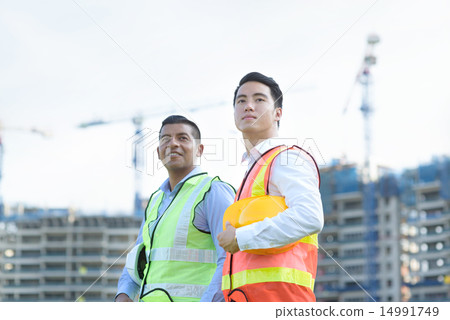 Construction team in front of construction site 14991749