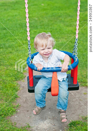 Cute baby boy playing on swing  14991867