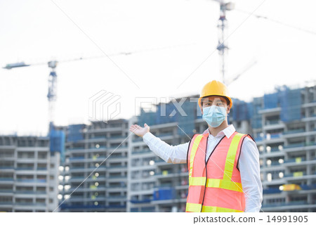 Chinese construction worker in front of work site Chinese construction worker in front of work site 14991905