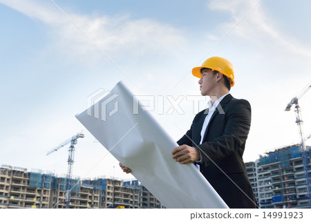 Young Chinese architect holding blueprints Young Chinese architect holding blueprints 14991923
