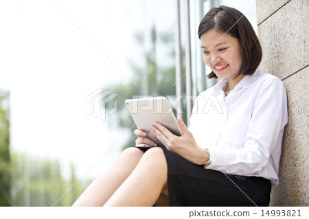 Asian young female executive looking at tablet Asian young female executive looking at tablet 14993821